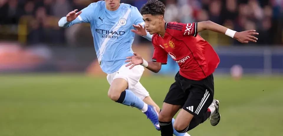 Player in red dribbling past opponent in blue
