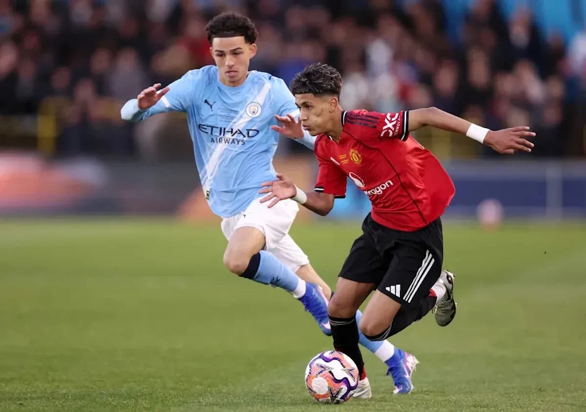 Player in red dribbling past opponent in blue