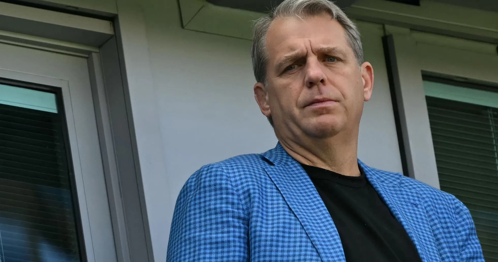 Man in blue blazer standing near window