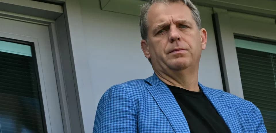 Man in blue blazer standing near window