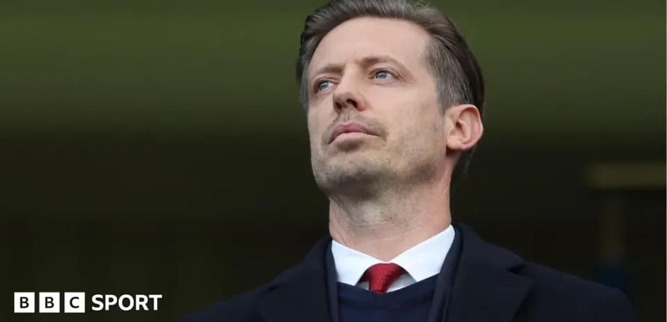 Man in suit observing from the stands
