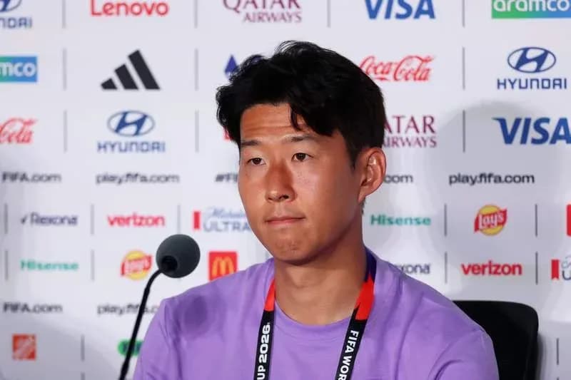 Player at press conference with sponsor logos behind