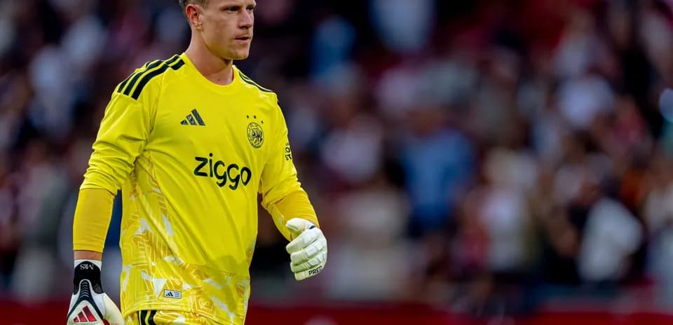 Goalkeeper wearing yellow kit walking on the pitch