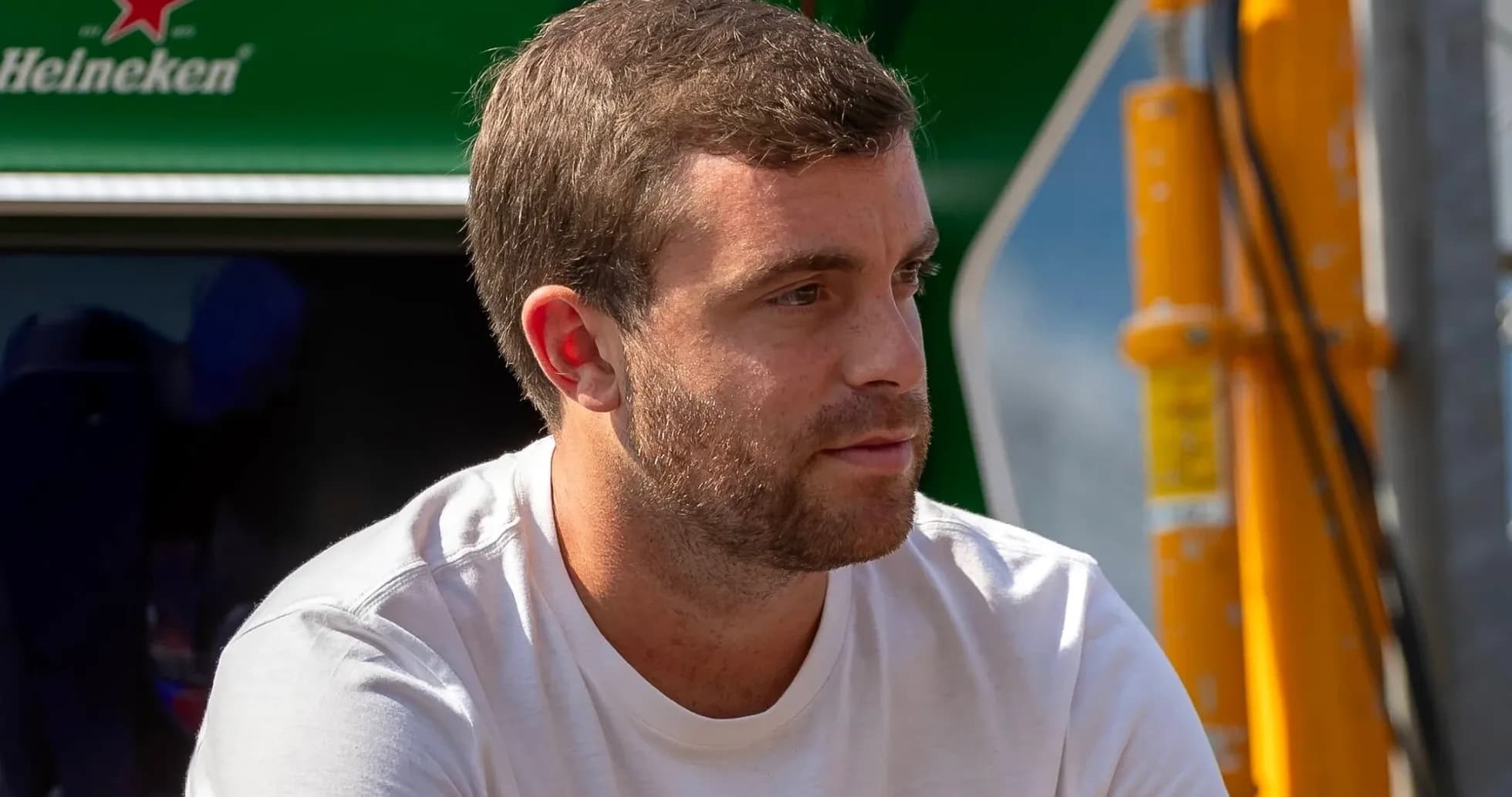 Man sitting near racing team's equipment area