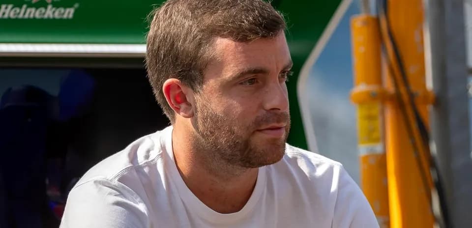 Man sitting near racing team's equipment area