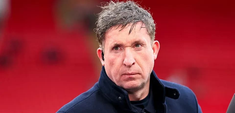 Man in a coat at a sports venue