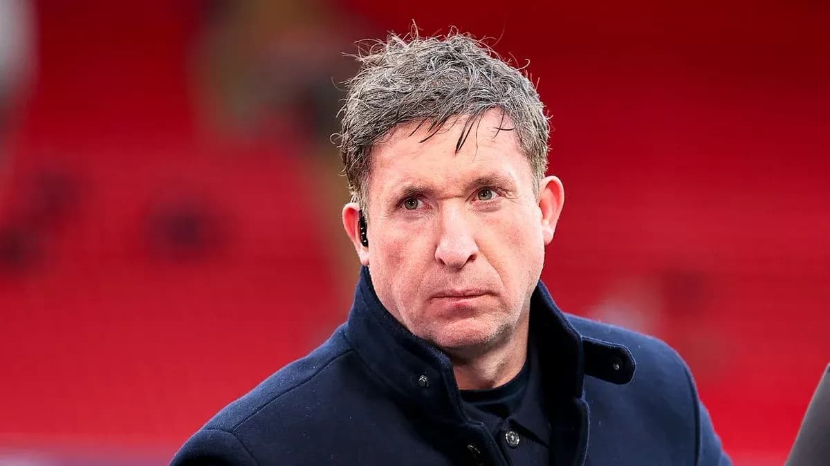 Man in a coat at a sports venue