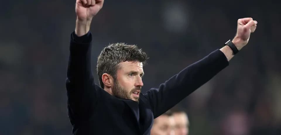 Coach celebrating with raised arms on sidelines