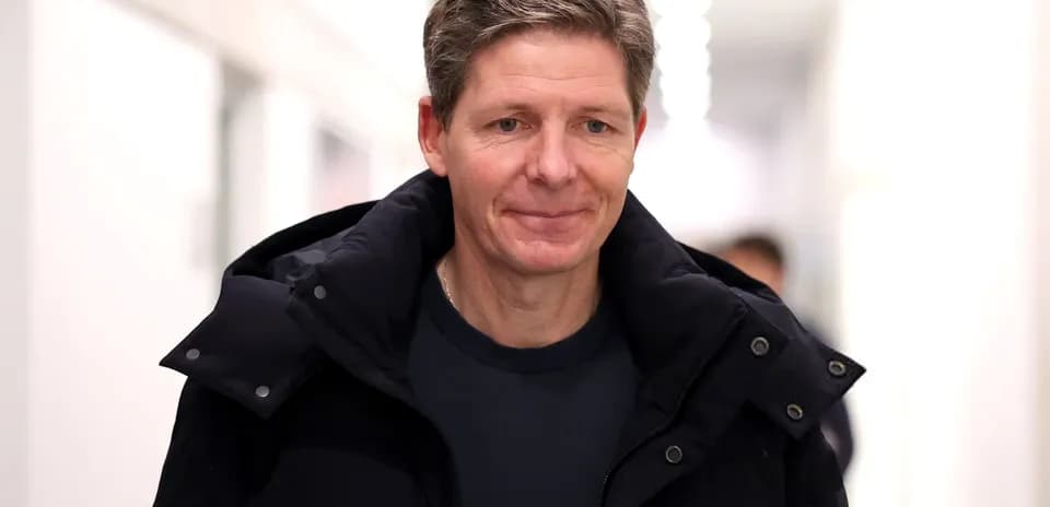 Man in a black jacket walking in hallway