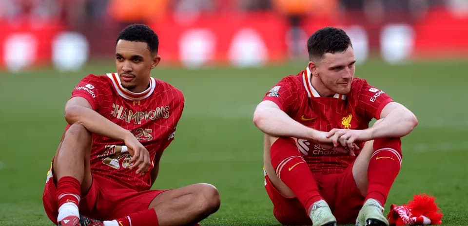 Two Liverpool players sitting on the pitch