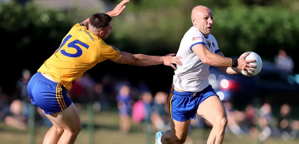 Player in white evading tackle while holding ball