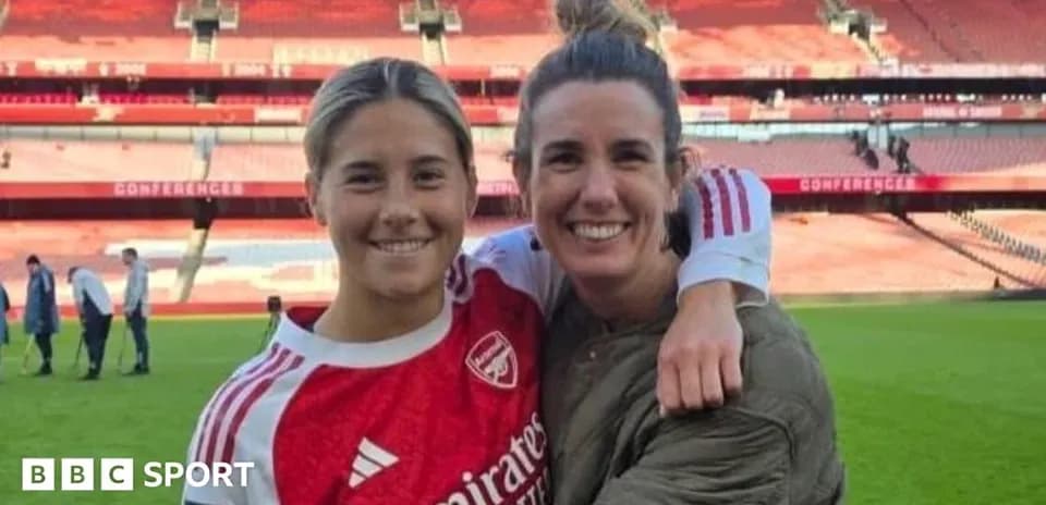 Two female football players posing on the pitch