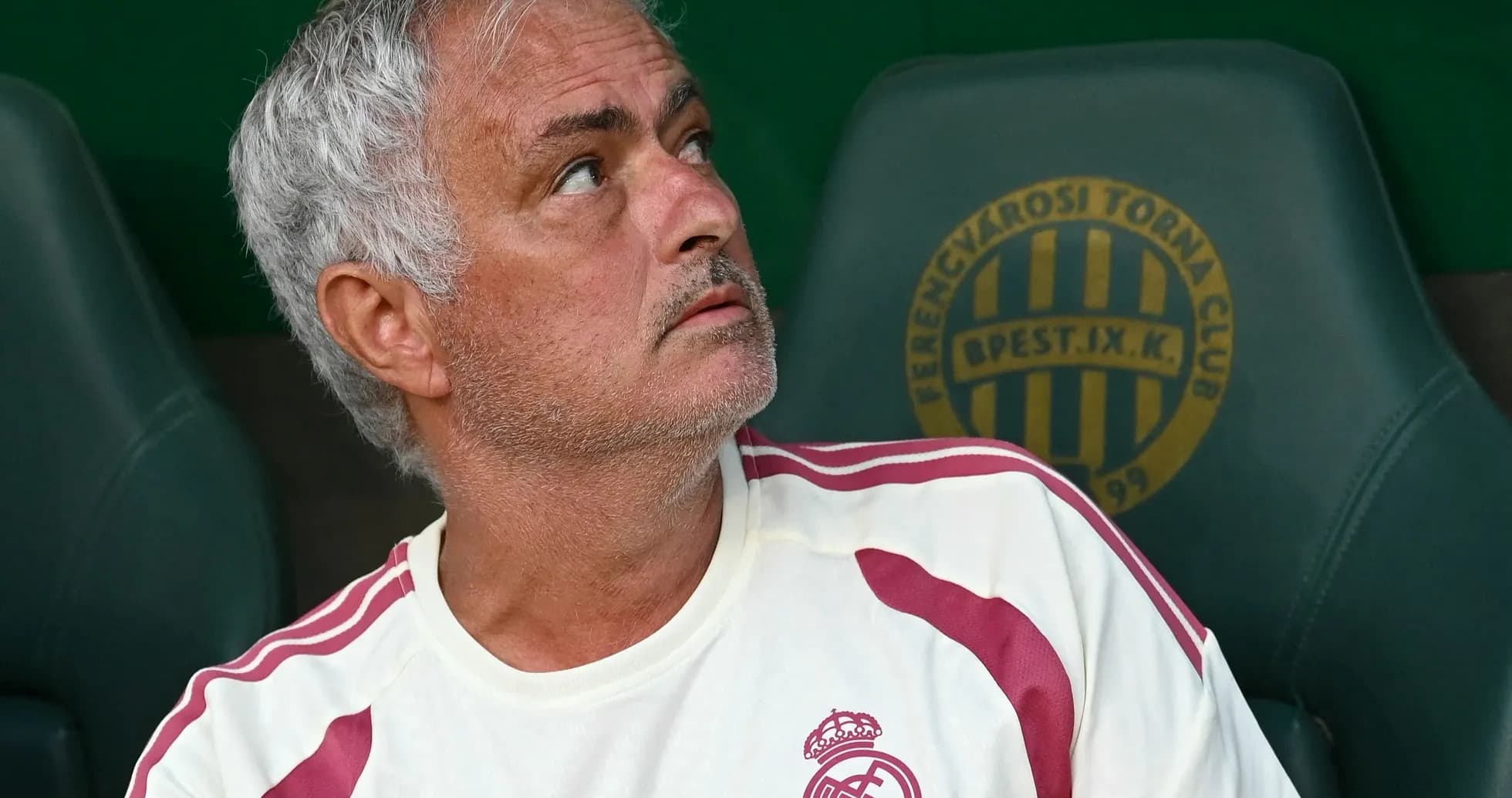 Coach sitting on bench looking upwards