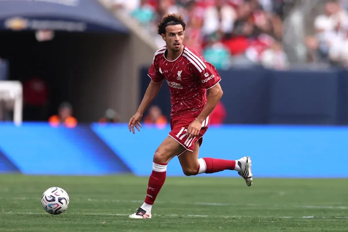 Player in red Liverpool kit dribbling the ball