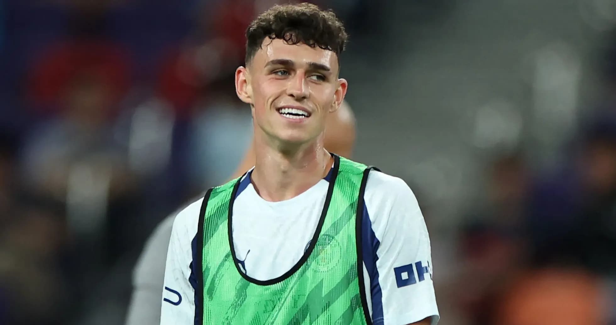 Player smiling while wearing training bib on pitch