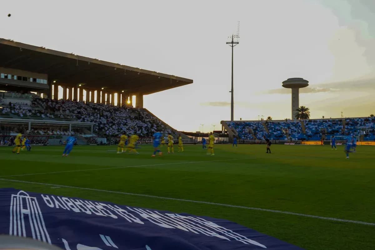 Players competing on the pitch at sunset
