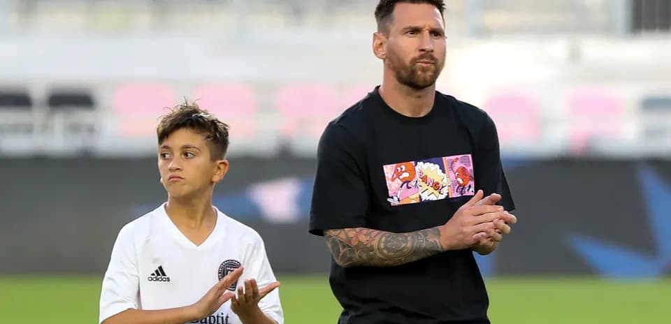 Lionel Messi and child clapping on the field