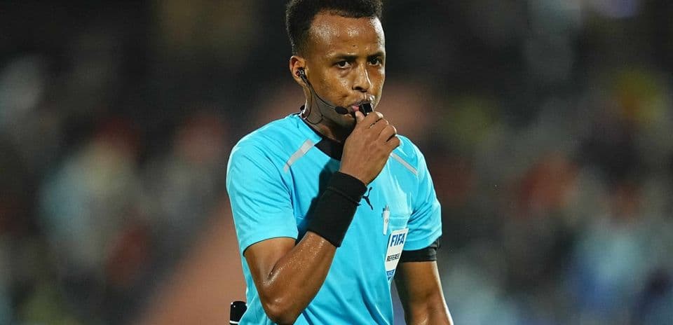 Referee holding whistle during a match