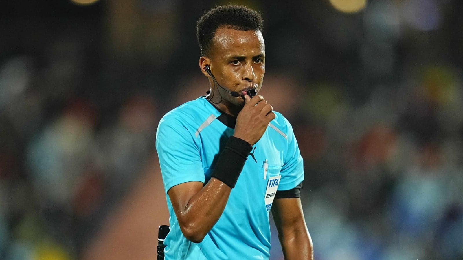Referee holding whistle during a match