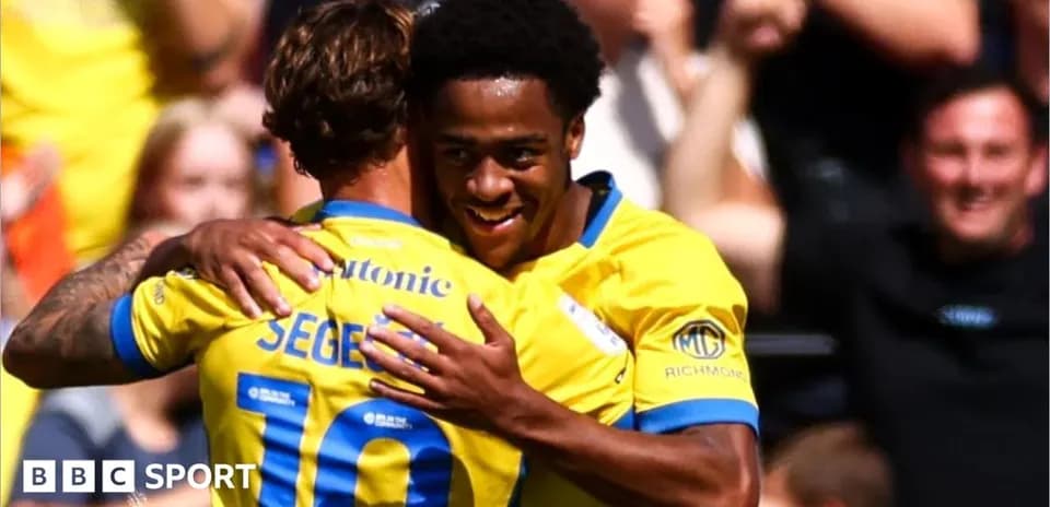 Two players celebrating a goal in yellow jerseys