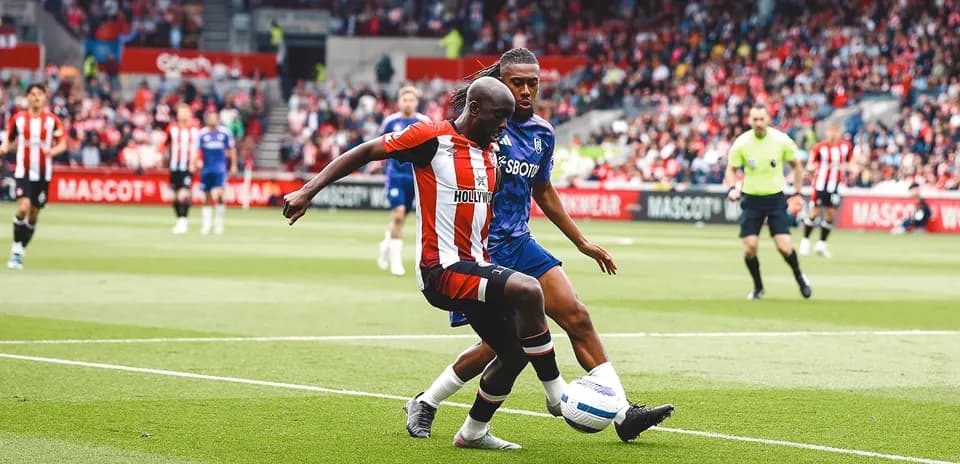 Brentford player tackles Fulham opponent during match