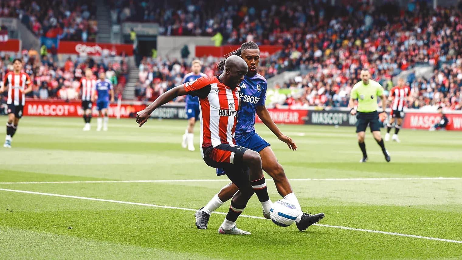 Brentford player tackles Fulham opponent during match