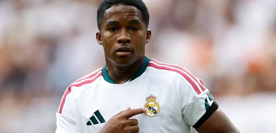 Player pointing to Real Madrid badge on jersey