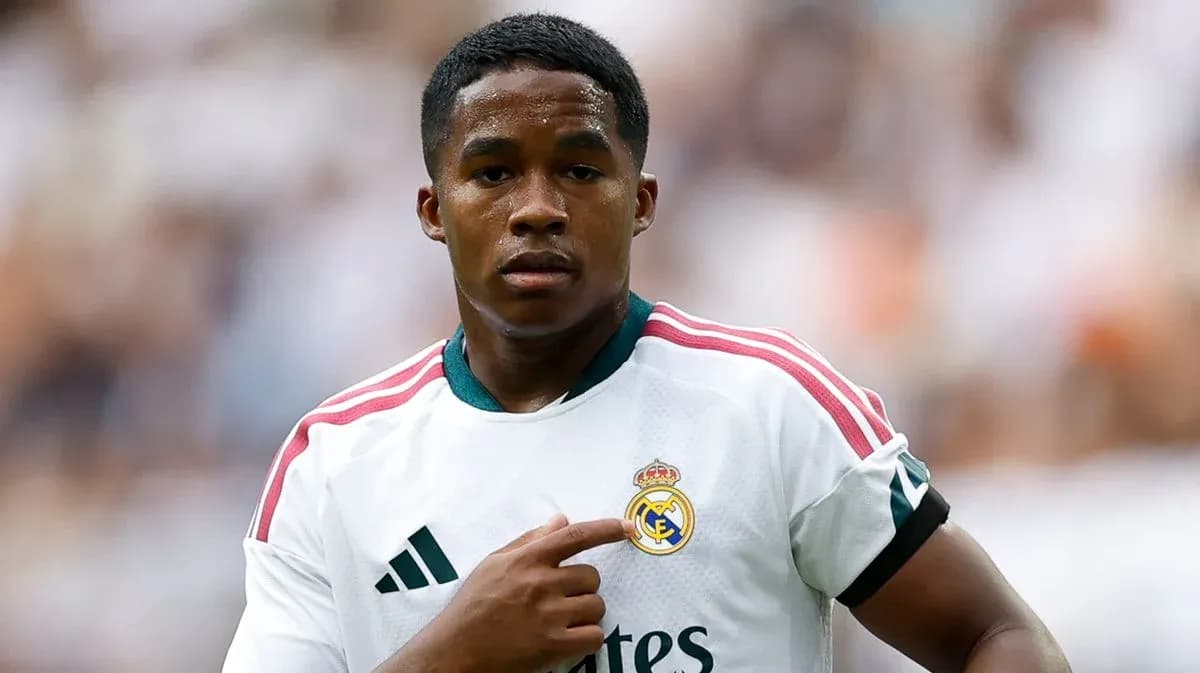 Player pointing to Real Madrid badge on jersey