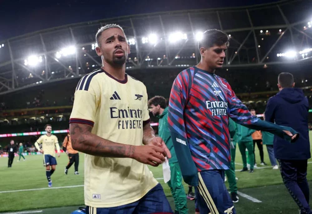 Two Arsenal players walking off the pitch after match