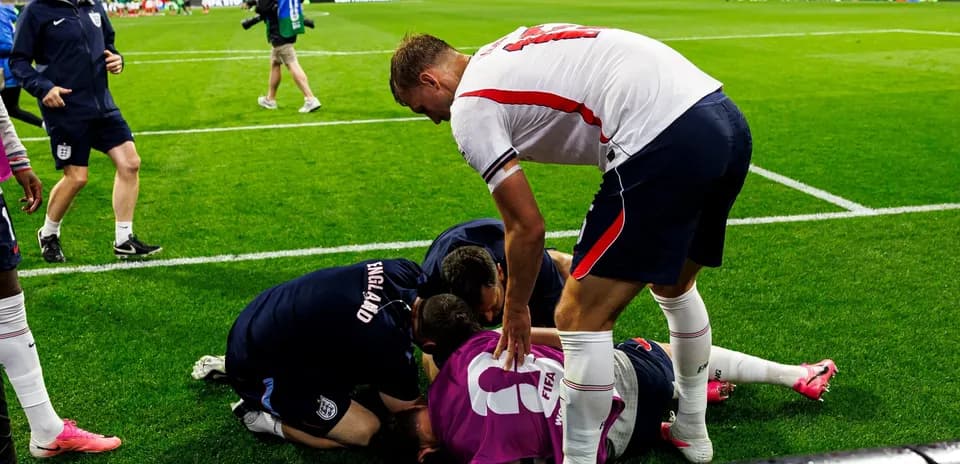 Players and staff attending to an injured goalkeeper