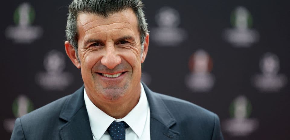 Smiling man in a suit at event backdrop