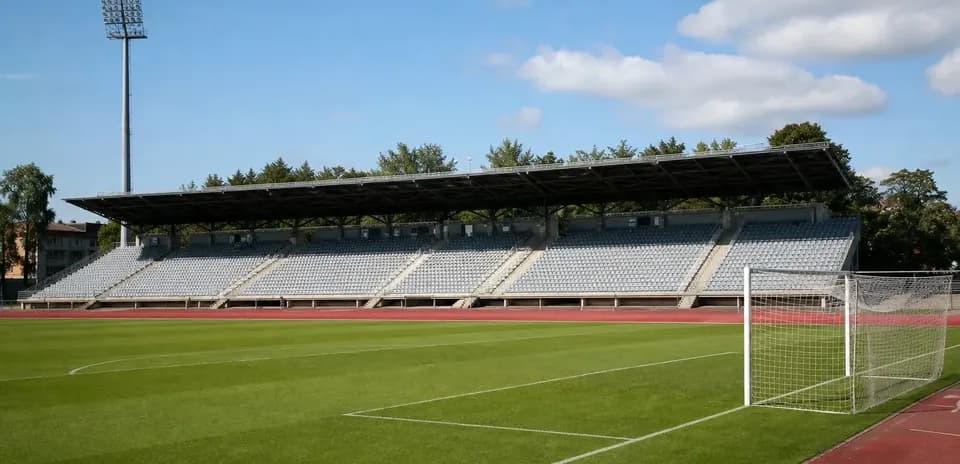 View of empty stadium with grass pitch and goal