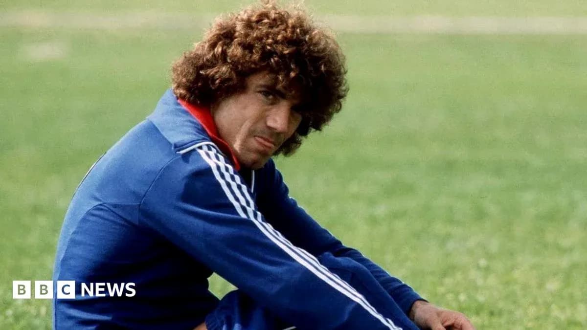 Football player sitting on grass field in training gear