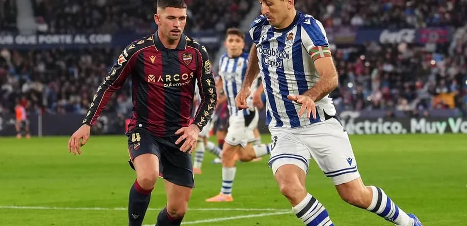 Real Sociedad player dribbling past Levante defender