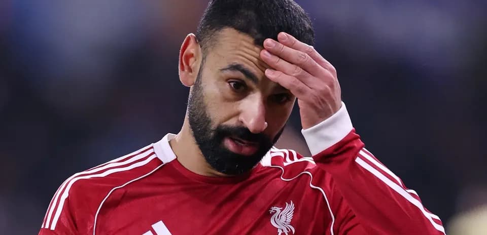 Player in red jersey holding forehead during match