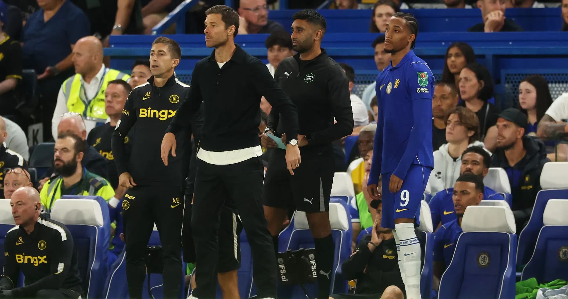 Coaching staff and player on bench during match