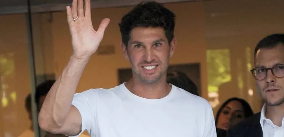 Player waving while leaving a building with others