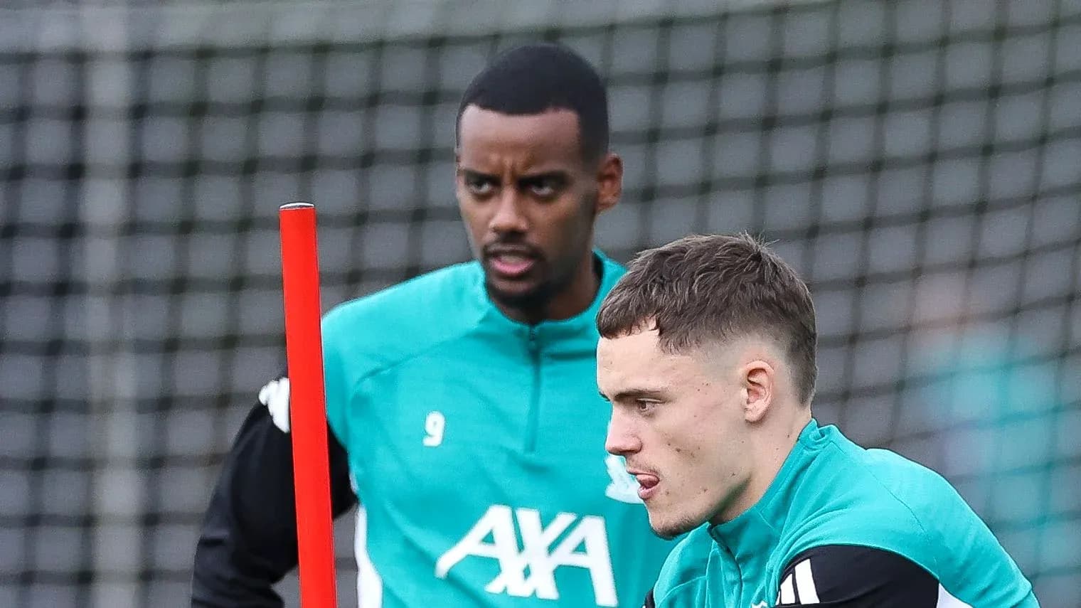 Two players training with a pole on the field