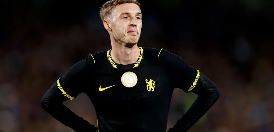 Player in black kit stands with hands on hips