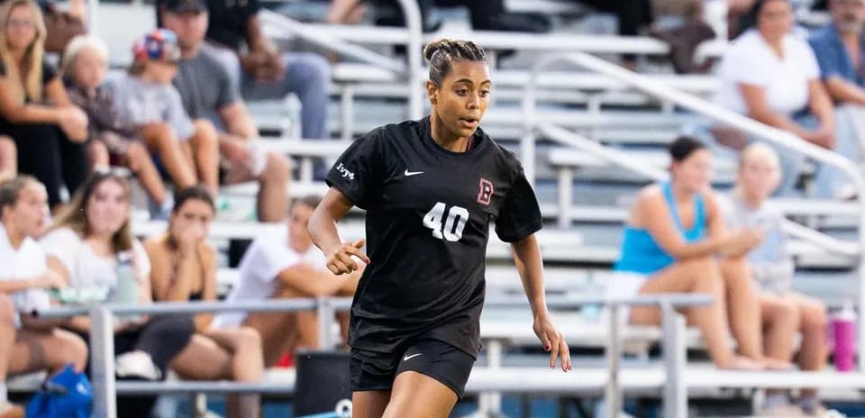 Player in black uniform running during soccer match