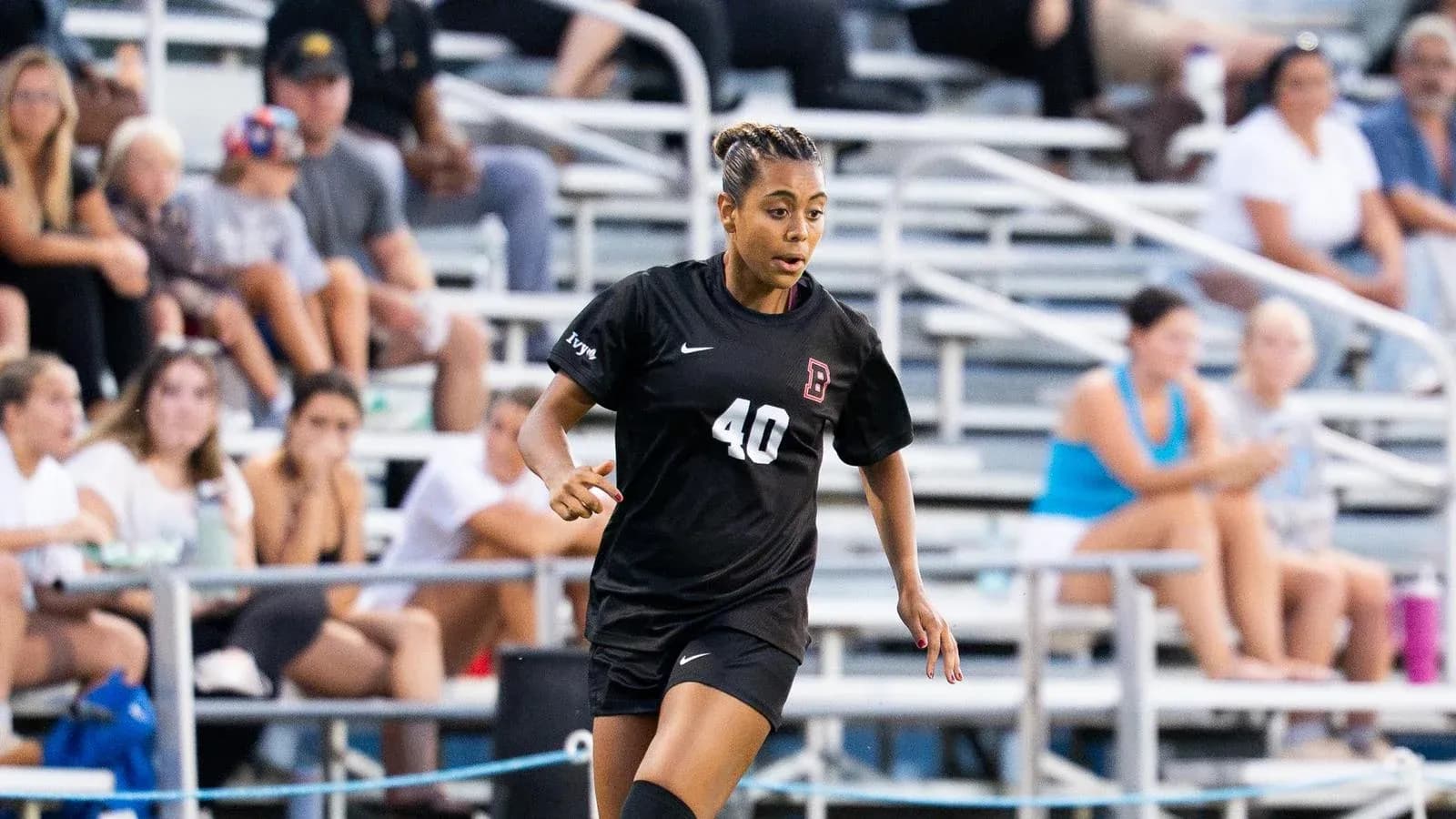 Player in black uniform running during soccer match