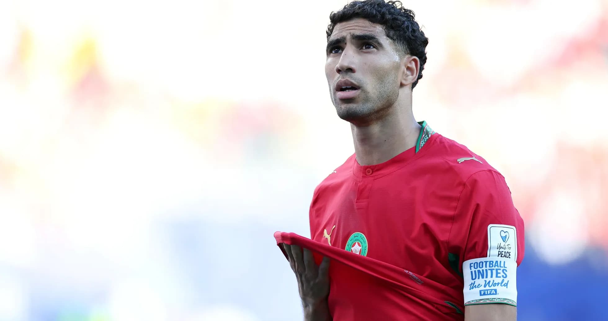 Player in red jersey adjusting shirt during match