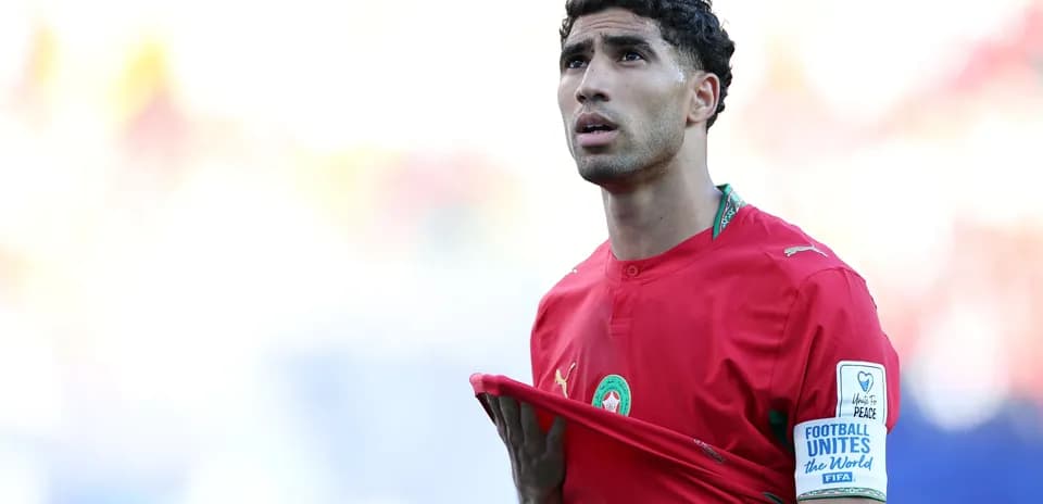Player in red jersey adjusting shirt during match