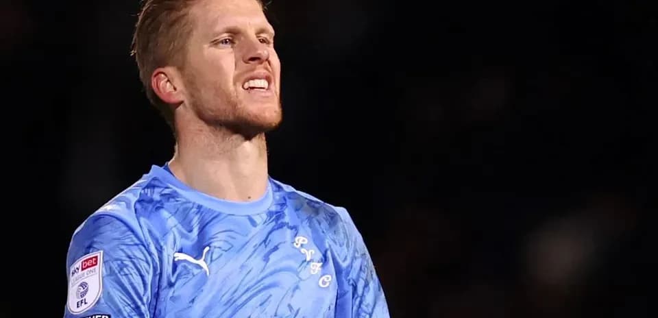 Goalkeeper in blue jersey during match action