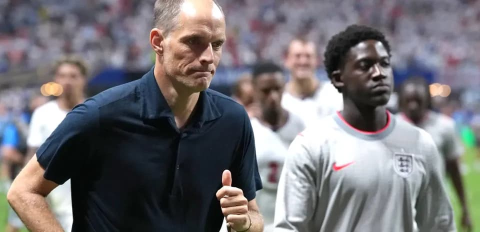 Coach and player walking off the pitch after match