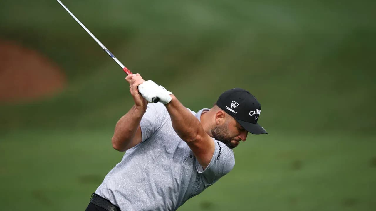 Golfer swinging club on course during play