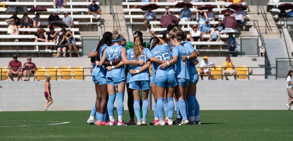 Team huddled together on the field before match