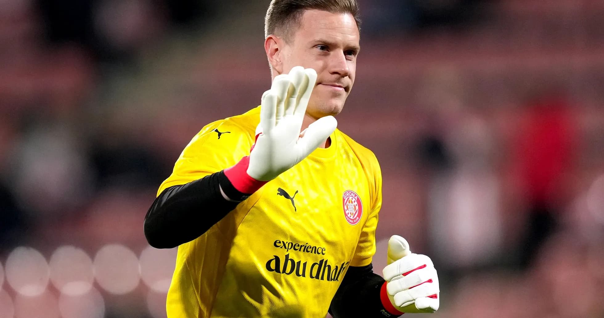 Goalkeeper waving in yellow kit before match