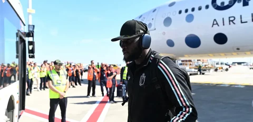 Player arriving at airport near aircraft and staff