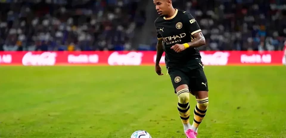 Player in black jersey dribbling soccer ball on field